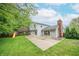 Large backyard featuring a playset, patio area and mature trees at 8772 W Evergreen Dr, Columbus, IN 47201