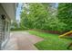 An open patio and backyard area, leading to a playset and wooded views at 8772 W Evergreen Dr, Columbus, IN 47201