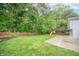 Open green backyard area, playground, wooden fence and additional covered parking at 8772 W Evergreen Dr, Columbus, IN 47201