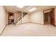 Large basement area with carpet, stairs, recessed lighting, and a door at 8772 W Evergreen Dr, Columbus, IN 47201
