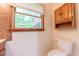 Bathroom featuring a toilet, cabinet, and window at 8772 W Evergreen Dr, Columbus, IN 47201