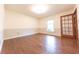 Spacious bedroom with hardwood floors, natural light from the window, and paneled accent wall at 8772 W Evergreen Dr, Columbus, IN 47201