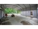 A covered carport with space to park lawn equipment and other outdoor items at 8772 W Evergreen Dr, Columbus, IN 47201
