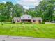 Well-maintained home with mature trees and an expansive green lawn at 8772 W Evergreen Dr, Columbus, IN 47201