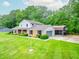 View of home showing attached garage, carport and large yard with lush greenery surrounding the property at 8772 W Evergreen Dr, Columbus, IN 47201