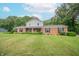 Charming two-story home exhibits a well-manicured lawn, complemented by a traditional brick facade and black shuttered windows at 8772 W Evergreen Dr, Columbus, IN 47201