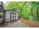 Exterior view of an outdoor shed, set against a wood-lined property at 8772 W Evergreen Dr, Columbus, IN 47201