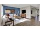 Bright living room features hardwood floors, a blue accent wall, and modern furniture at 8820 Alexander Ridge Dr, McCordsville, IN 46055