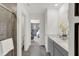 Bright bathroom featuring a double vanity, tiled shower, and access to the main bedroom at 8853 Alexander Ridge Dr, McCordsville, IN 46055