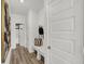 Hallway with white wainscotting, hall tree with hooks and bench, and wood floors, creating a welcoming space at 8853 Alexander Ridge Dr, McCordsville, IN 46055