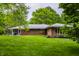 Spacious backyard showcasing a brick home with an open lawn area, ideal for recreation and enjoying nature at 8905 Washington Blvd West Dr, Indianapolis, IN 46240