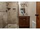 Bathroom featuring a glass-enclosed shower with stone tile, a vanity and an oval mirror at 8905 Washington Blvd West Dr, Indianapolis, IN 46240