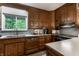 Classic kitchen design with wood cabinets, a stainless sink, and a view of the backyard through a window at 8905 Washington Blvd West Dr, Indianapolis, IN 46240