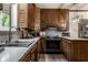 Traditional kitchen featuring oak cabinets, stainless steel sink, and modern black appliances at 8905 Washington Blvd West Dr, Indianapolis, IN 46240