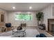 Inviting living room featuring vinyl floors, a fireplace, and a large window with green views at 8905 Washington Blvd West Dr, Indianapolis, IN 46240