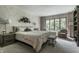 Comfortable primary bedroom with neutral tones, a large bed, seating area and lots of natural light at 8905 Washington Blvd West Dr, Indianapolis, IN 46240