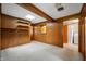 Spacious bonus room with wood paneled walls, skylight, built-in shelving, and adjacent laundry area at 924 N Devon Ave, Indianapolis, IN 46219