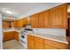 Functional kitchen with light oak cabinets, white appliances, and ample counter space at 924 N Devon Ave, Indianapolis, IN 46219