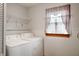 Practical laundry room with washer, dryer, and storage shelving at 924 N Devon Ave, Indianapolis, IN 46219