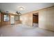 Open living room with wood-paneled walls, ceiling fan, and neutral carpeting at 924 N Devon Ave, Indianapolis, IN 46219