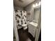 Well-lit full bath including vanity with storage, floral shower curtain, and decorative mirror at 9507 Colony Pointe E Dr, Indianapolis, IN 46250