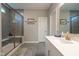Bathroom with a glass shower featuring grey tiled walls, a sink with a quartz countertop, and a large mirror at 9741 Haughton Ln, McCordsville, IN 46055