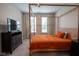 This bedroom boasts a stylish wooden canopy bed, soft gray walls, and bright natural light from two windows at 9741 Haughton Ln, McCordsville, IN 46055