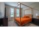 This bedroom boasts a stylish wooden canopy bed, soft gray walls, and bright natural light from two windows at 9741 Haughton Ln, McCordsville, IN 46055