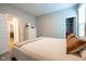 Neutral bedroom featuring tan upholstered headboard, soft throw blanket, closet access, and a bright window at 9741 Haughton Ln, McCordsville, IN 46055