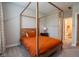 This bedroom boasts a stylish wooden canopy bed, soft gray walls, and access to an adjacent bathroom at 9741 Haughton Ln, McCordsville, IN 46055