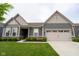 Inviting single-story home with manicured lawn, garden beds and a convenient two-car garage at 9741 Haughton Ln, McCordsville, IN 46055
