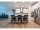 Kitchen island features seating and stylish pendant lighting with stainless steel appliances and modern finishes at 9741 Haughton Ln, McCordsville, IN 46055