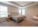 Serene main bedroom featuring a tray ceiling, carpeted floors, large windows, and ample natural light at 9741 Haughton Ln, McCordsville, IN 46055