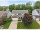 Aerial view of a two-story home featuring manicured lawn, brick accents, and a paved driveway at 9756 Brook Meadow Dr, McCordsville, IN 46055
