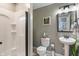 Clean bathroom with a shower, pedestal sink, and neutral decor at 9756 Brook Meadow Dr, McCordsville, IN 46055