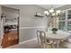 Bright dining room featuring a modern chandelier and a view into the living room at 9756 Brook Meadow Dr, McCordsville, IN 46055