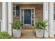 Charming front door with a decorative wreath and potted plants creating a welcoming entrance at 9756 Brook Meadow Dr, McCordsville, IN 46055