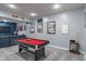 Spacious game room with a pool table, framed sports memorabilia, and plush gray carpet at 9756 Brook Meadow Dr, McCordsville, IN 46055