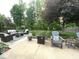 Well-maintained patio with wicker seating, Adirondack chairs, a fire pit, and a manicured lawn at 9756 Brook Meadow Dr, McCordsville, IN 46055