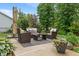 Inviting patio featuring comfortable wicker furniture, an umbrella, and a beautifully landscaped backyard at 9756 Brook Meadow Dr, McCordsville, IN 46055