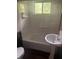 Bright bathroom featuring a pedestal sink, tub-shower, and a window providing natural light at 988 Westfield Rd, Noblesville, IN 46062