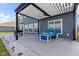 Inviting covered back patio with a fire table and bright blue Adirondack chairs provides comfortable outdoor living space at 9917 Gallop Ln, Fishers, IN 46040