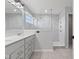 Bright bathroom featuring a double vanity, large walk-in shower with glass surround and neutral gray tile at 9917 Gallop Ln, Fishers, IN 46040