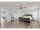 Relaxing main bedroom with hardwood floors, a ceiling fan, and a statement mirror at 9917 Gallop Ln, Fishers, IN 46040