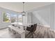 Bright dining room with large windows, a long white table, bench seating and modern light fixture at 9917 Gallop Ln, Fishers, IN 46040