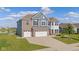 Beautiful two-story home boasts brick and siding details, a three-car garage and well manicured lawn at 9917 Gallop Ln, Fishers, IN 46040