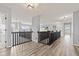 Bright hallway features wood-look floors, modern lighting, and dark wood railings on the second level at 9917 Gallop Ln, Fishers, IN 46040