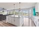 Open-concept kitchen with white cabinets, a central island, and seamless transition to the living area at 9917 Gallop Ln, Fishers, IN 46040