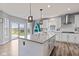 Kitchen with white cabinets and an island, opening up to a view of the backyard and patio at 9917 Gallop Ln, Fishers, IN 46040