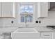 Close-up of a kitchen sink area with granite countertops and subway tile backsplash, offering a view to the outdoors at 9917 Gallop Ln, Fishers, IN 46040